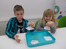 Dziewczynka i chklopiec podczas wykonywania doświadczenia z wodą