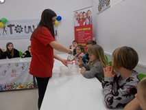 Pani instruuje dzieci, jak wykonać doświadczenie