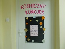 Plakat zawieszony na drzwiach, z napisem ,,Co to jest grawitacja