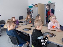 Dzieci siedzą przy stole, podczas prezentacji w Obserwatorium