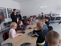 Dzieci siedzą przy stole, podczas prezentacji w Obserwatorium