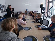 Dzieci siedzą przy stole, podczas prezentacji w Obserwatorium