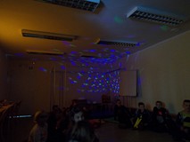 Dzieci w sali bibliotecznej oświetlonej kolorowymi światełkami imitującymi gwiazdy