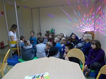 Bibliotekarka czyta dzieciom fragmenty ksiązek o kosmosie