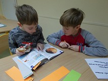 Dzieci wypisują ciekawostki o kosmosie z książek