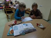 Dzieci wypisują ciekawostki o kosmosie z książek