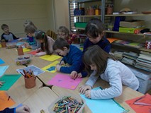 Przedszkolaki przy stołach malują obrazki do przeczytanego opowiadania