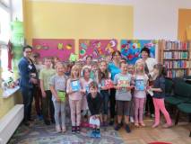 Uczestnicy Wakacji w Bibliotece przy stole tworza prace plastyczne