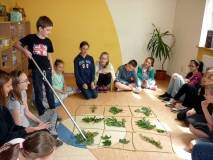 Uczestnicy Wakacji w Bibliotece przy stole tworza prace plastyczne