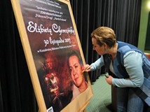 Elżbieta Cherezińska po spotkaniu autorskim w Koszalińskiej Bibliotece Publicznej podpisuje plakat p