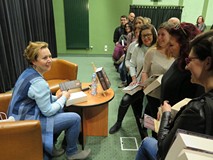 Elżbieta Cherezińska po spotkaniu autorskim w Koszalińskiej Bibliotece Publicznej podpisuje książki 
