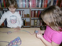 Dziewczynki robią kłębuszki z wełny