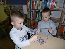 Chłopcy robią kłębuszki z wełny