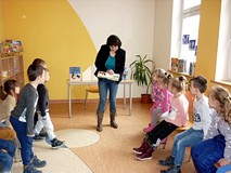 Bibliotekarka pokazuje dzieciom książeczki o przyjaźni