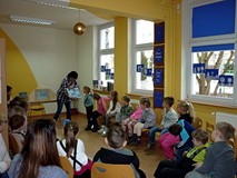 Bibliotekarka pokazuje dzieciom książeczki o przyjaźni