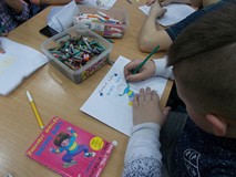 Chłopiec podczas malowania okładki książki