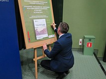 Autor publikacji, Andrzej Giza składa pamiątkowy autograf