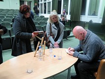 Cezary Harasimowicz rozdaje pamiątkowe autografy po spotkaniu