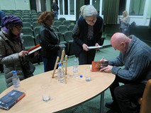 Cezary Harasimowicz rozdaje pamiątkowe autografy po spotkaniu