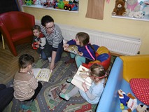 Dzieci z bibliotekarką oglądają przygotowane książki o ptakach