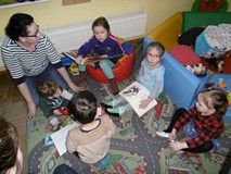 Dzieci z bibliotekarką oglądają przygotowane książki o ptakach