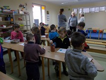 Grupa przy stołach ze swoimi rysunkami