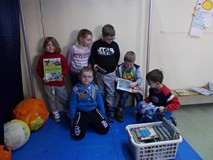 Kilkoro dzieci na scenie z książeczkami