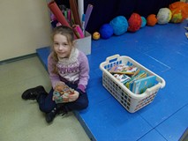 Dziewczynka na scenie, obok kosz z książkami