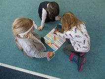 Trzy dziewczxynki oglądają ksiązkę