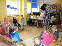 Pani Wiola zadaje dzieciom literackie zagadki, pokazując ilustracje do znanych baśni