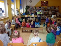 Bibliotekarka pokazuje dzieciom najciekawsze książeczki dla najmłodszych, z naszych zbiorów