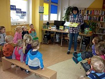 Bibliotekarka pokazuje dzieciom najciekawsze książeczki dla najmłodszych, z naszych zbiorów