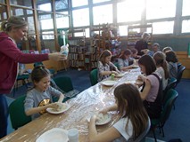Dzieci przy stołach tworzą prace z masy solnej