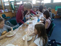 Bibliotekarka pomaga dzieciom w tworzeniu masy solnej
