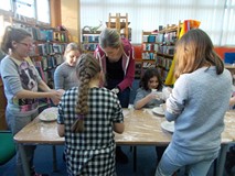 Dzieci przy stołach tworzą prace z masy solnej