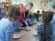 Dzieci przy stołach tworzą prace z masy solnej