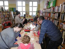 Dzieci z rodzicami podczas zajęć plastycznych.
