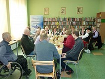 uczestnicy siedzą przy stołach i rozmawiają