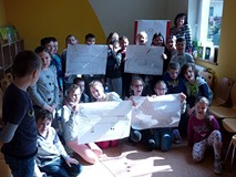 Wspólna fotografia, na której dzieci prezentują wykonane portrety konia Alfonso