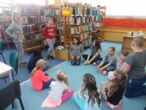 Dzieci siedzą w kole na dywanie podczas wspólnej zabawy