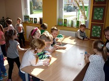 Dzieci szukają obrazków, których nazwy zaczynają się na wylosowaną literkę
