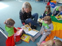 Bibliotekarka czyta dzieciom wybrane ksiązki