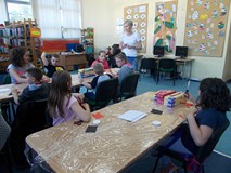 Dzieci siedza przy stołach podczas wykonywania prac plastycznych