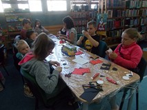 Dzieci siedza przy stołach podczas wykonywania prac plastycznych