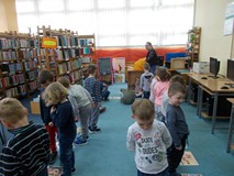 Dzieci tańczą wokół ilustracji przedstawiających bohaterów książek