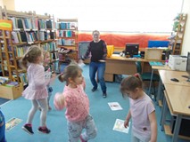 Dzieci tańczą z bibliotekarką w rytm muzyki