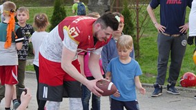Przedstawiciel Grupy Barbarians Koszalin uczy grać w rugby małego zawodnika
