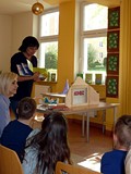 Pani Wiola pokazuje dzieciom książeczki do nauki abecadła i poznawania literek