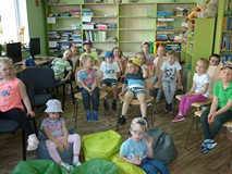 Dzieci podczas słuchania i oglądania teatrzyku KAMISHIBAI
