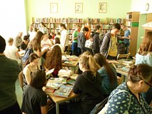 Uczestnicy wybieraja książki i czytają je w ciszy